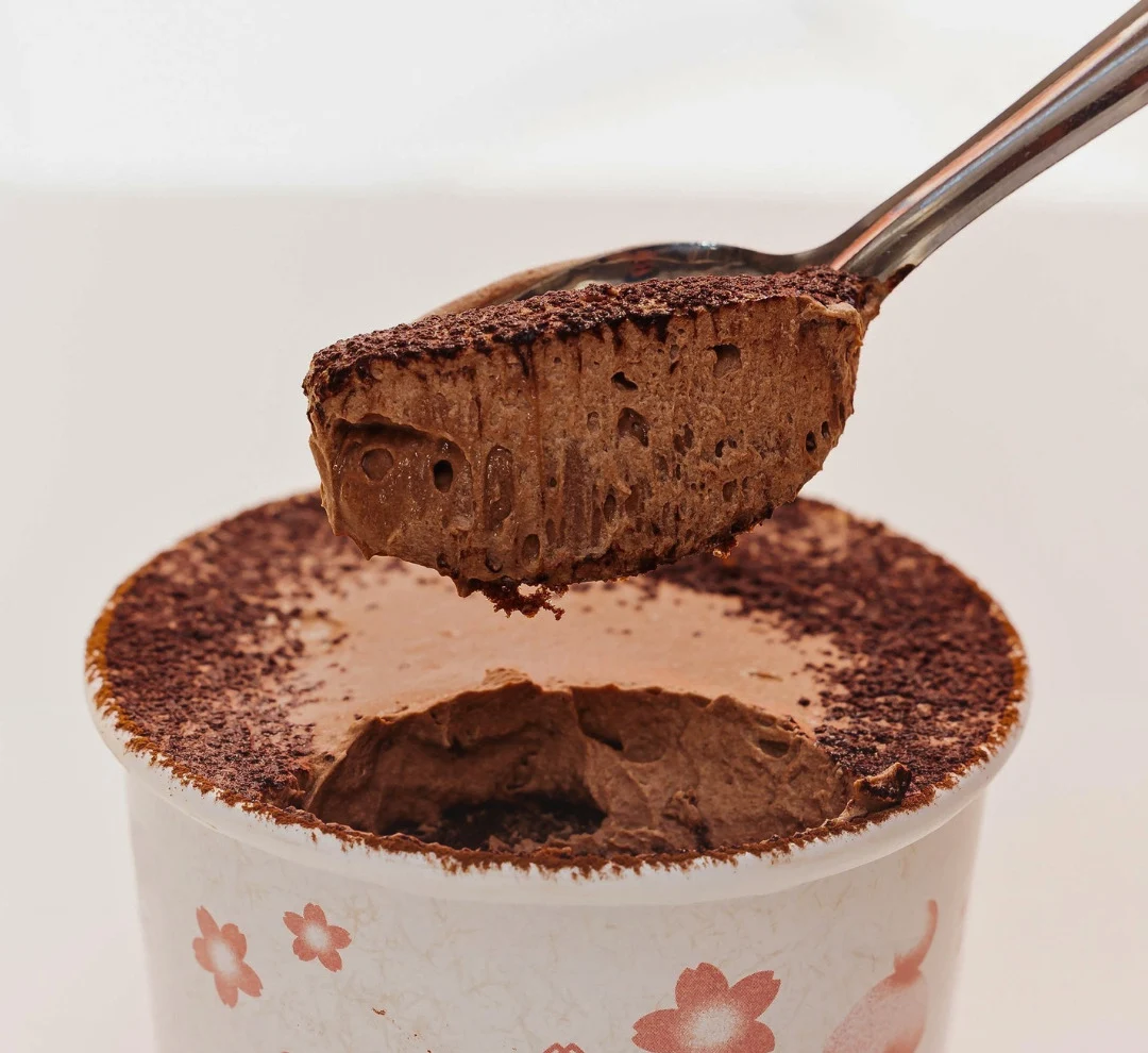 Sobremesa de chocolate da AMAY em copo com a flor rosa da marca